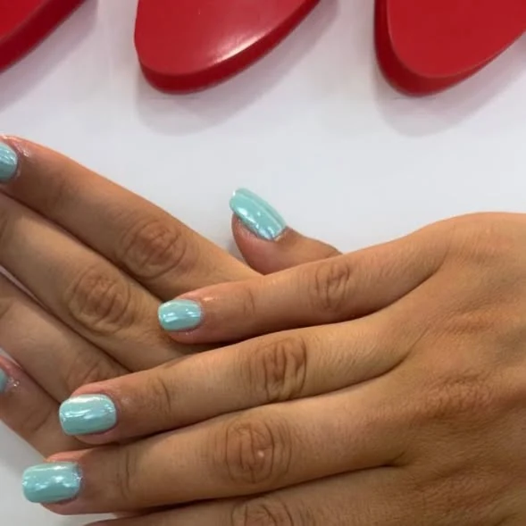 Manucure vernis vert d'eau brillant.